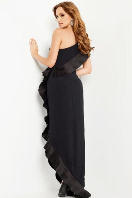 Model showing the back of the Jovani 26160 black one-shoulder gown with ruffle details.